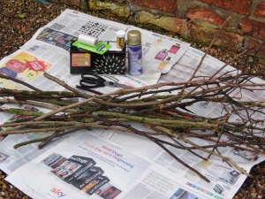 You will need: 15 dry sticks, newspaper, string, scissors, gold spray paint, gold glitter, string of 100 fairy lights