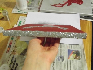 Apply glue to the edges of your canvas and cover with glitter.