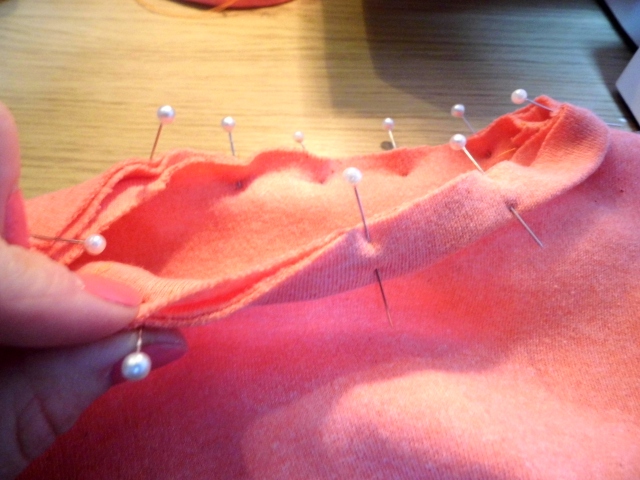 Find the center point at the back of your neckline and pin the center of the neckband. You will pin all three raw edges together.